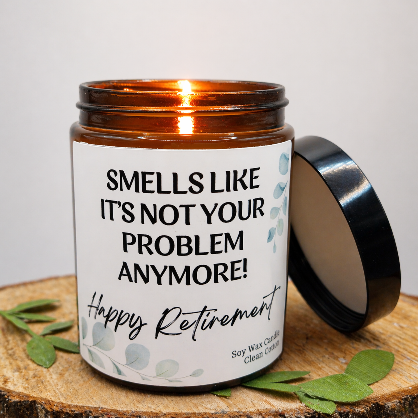 Candle jar with a humorous label on a wooden surface Candle with humorous label and matchbox on a wooden surface - funny smells like not your problem anymore happy retirement candle