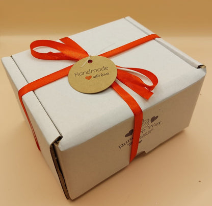 White box with a red ribbon and a round tag on a beige background