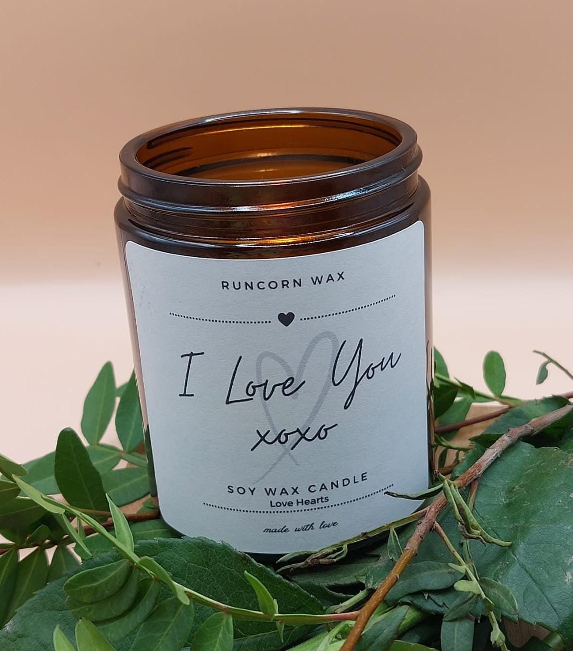 Candle with 'I Love You  label on a leafy background