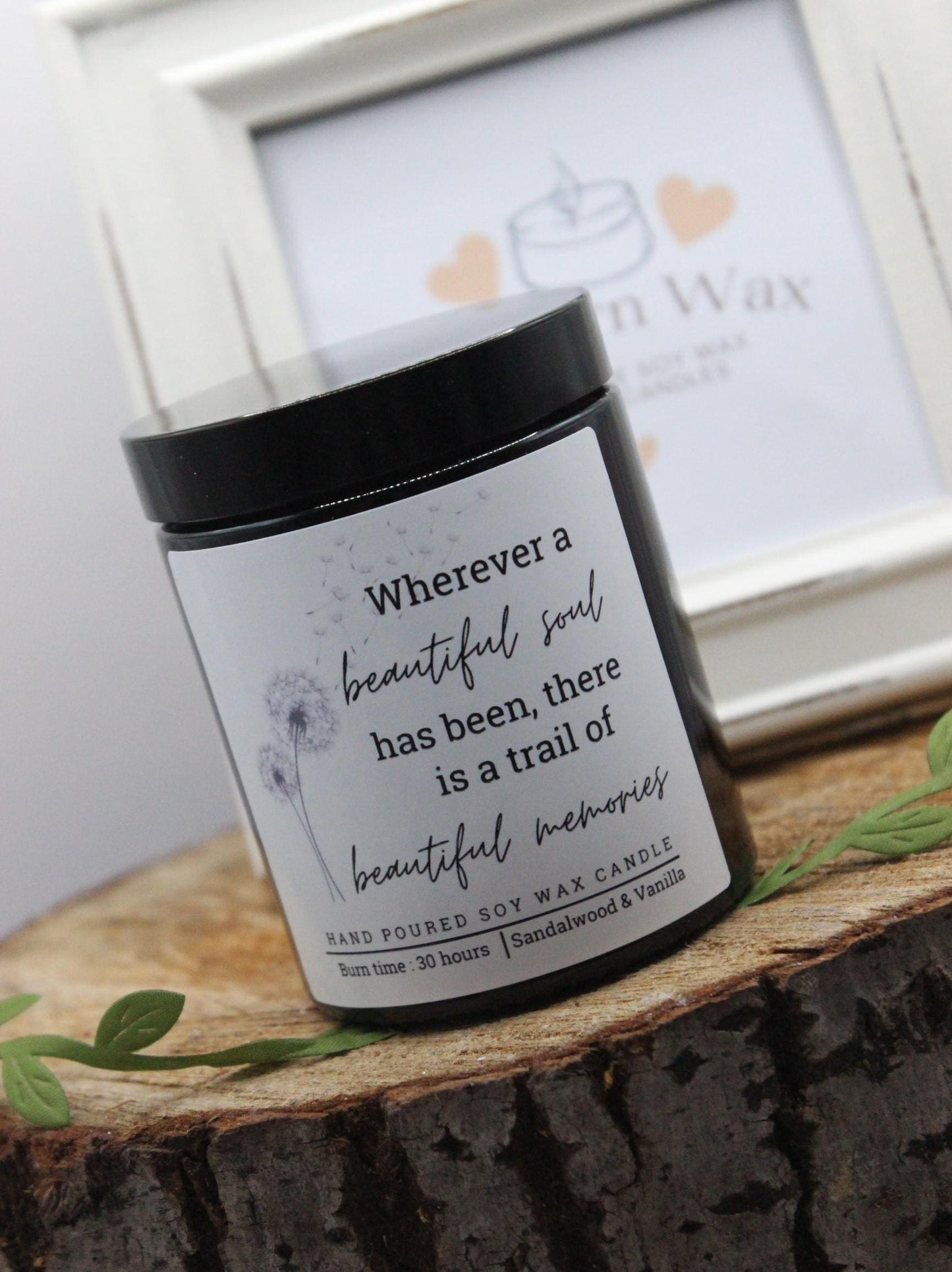 Candle jar with a quote on a wooden surface with a blurred background