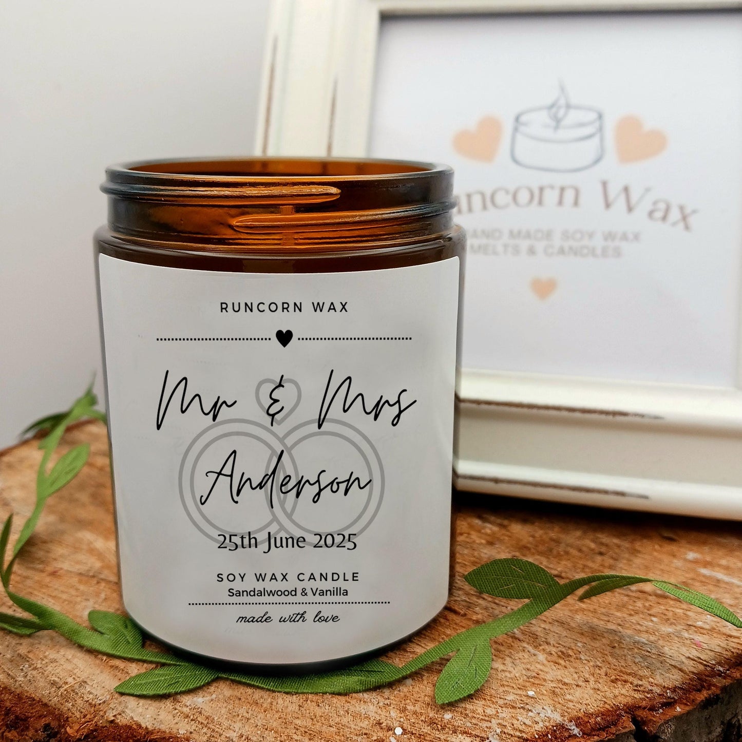 Personalized candle with 'Mr & Mrs Anderson' on a wooden surface, Runcorn Wax brand visible.