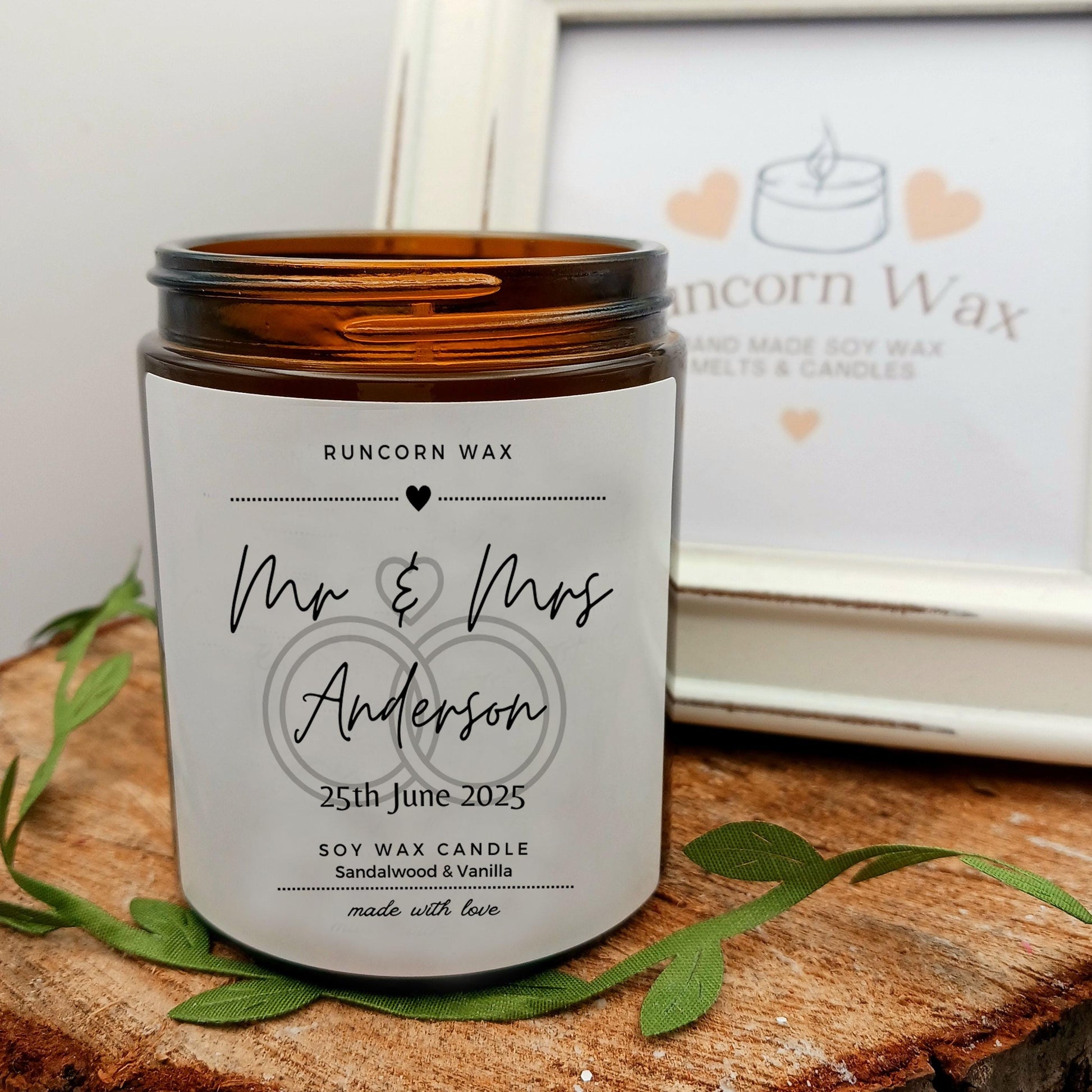 Personalized candle with 'Mr & Mrs Anderson' on a wooden surface, Runcorn Wax brand visible.