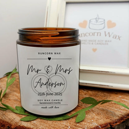 Personalized candle with 'Mr & Mrs Anderson' on a wooden surface, Runcorn Wax brand visible.