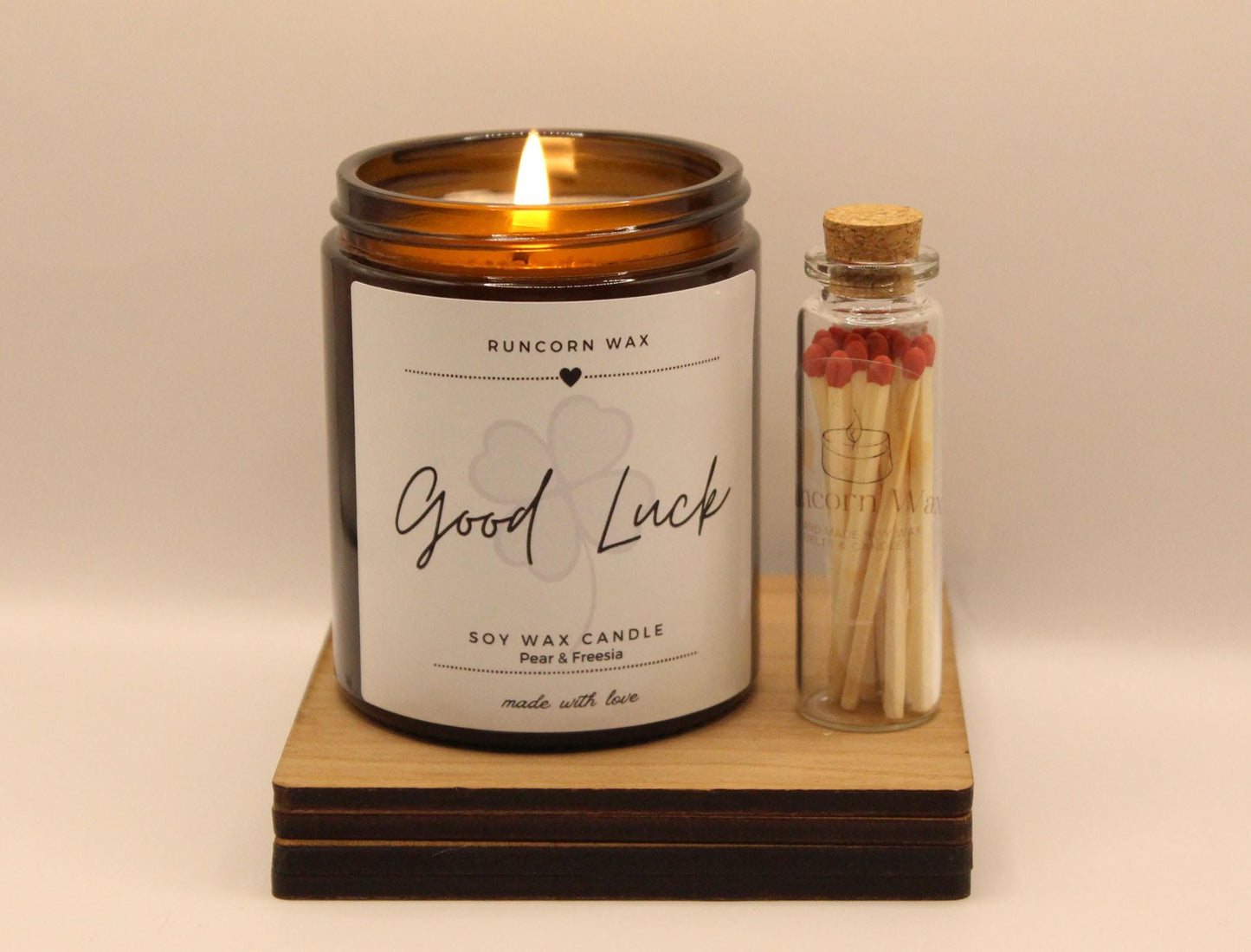 Candle labeled 'Good Luck' with matches on a beige background