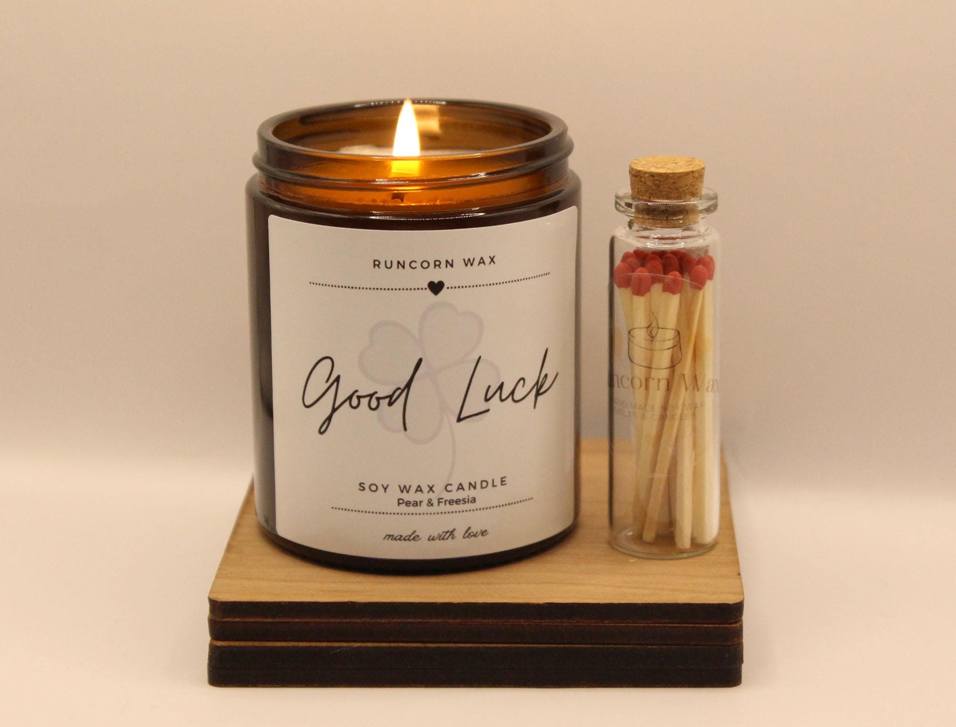 Candle labeled 'Good Luck' with matches on a beige background