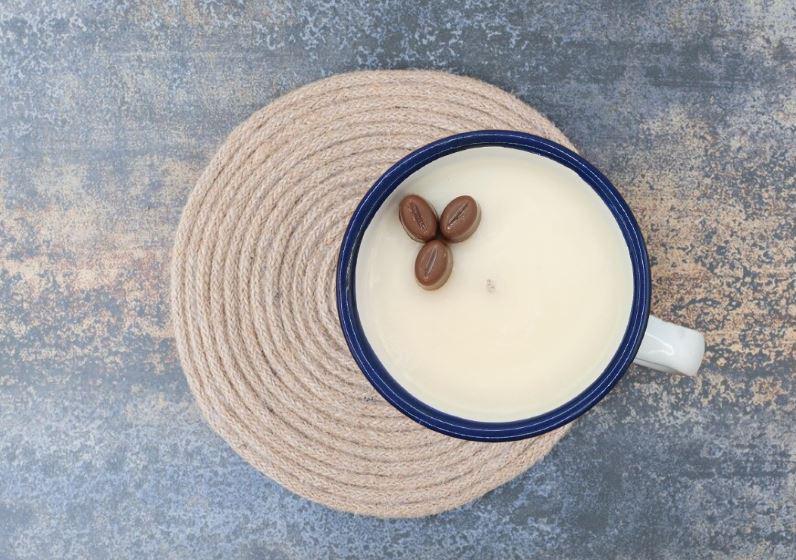 Blue mug with coffee beans on a textured surface