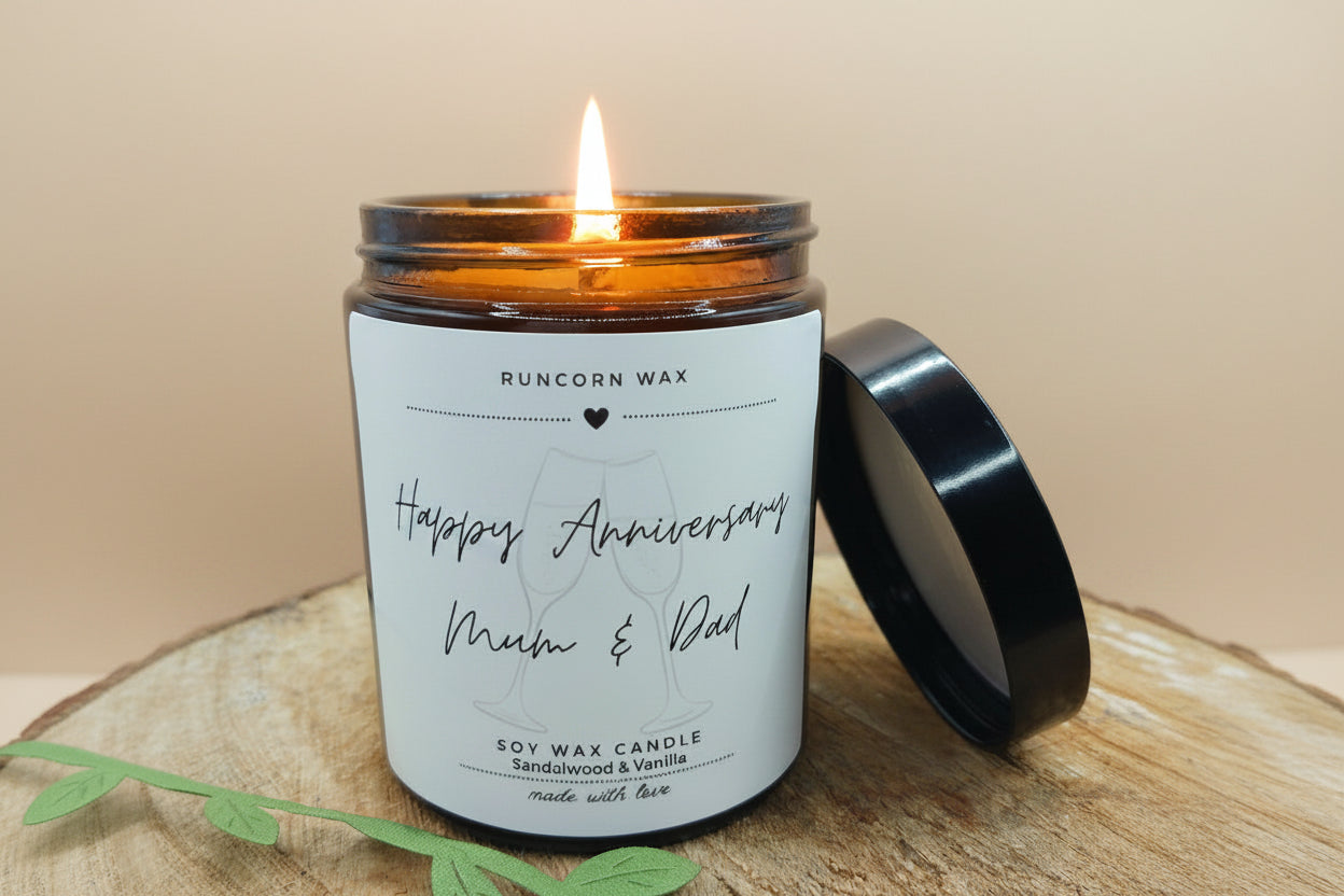 Candle with a 'Happy Anniversary Mum & Dad' label on a wooden surface