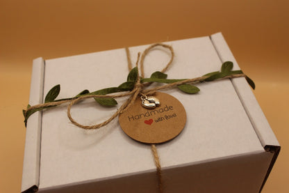 White box with string, leaves, and a 'Handmade with Love' tag on a brown background