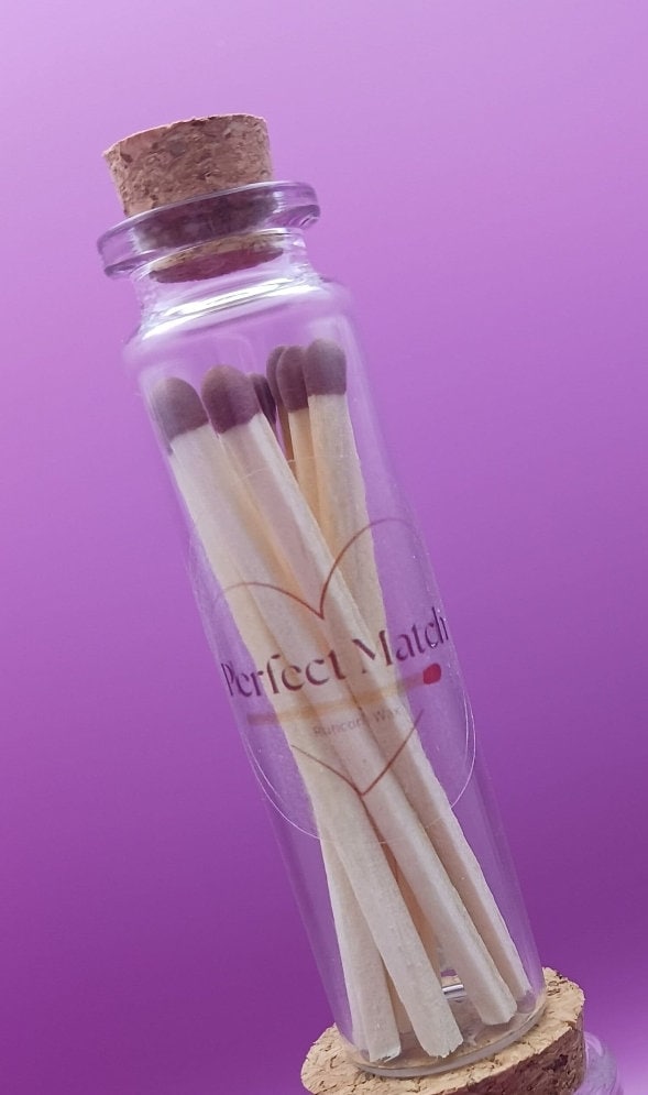 Matches labeled 'Perfect Match' in a glass bottle with a cork on a purple background