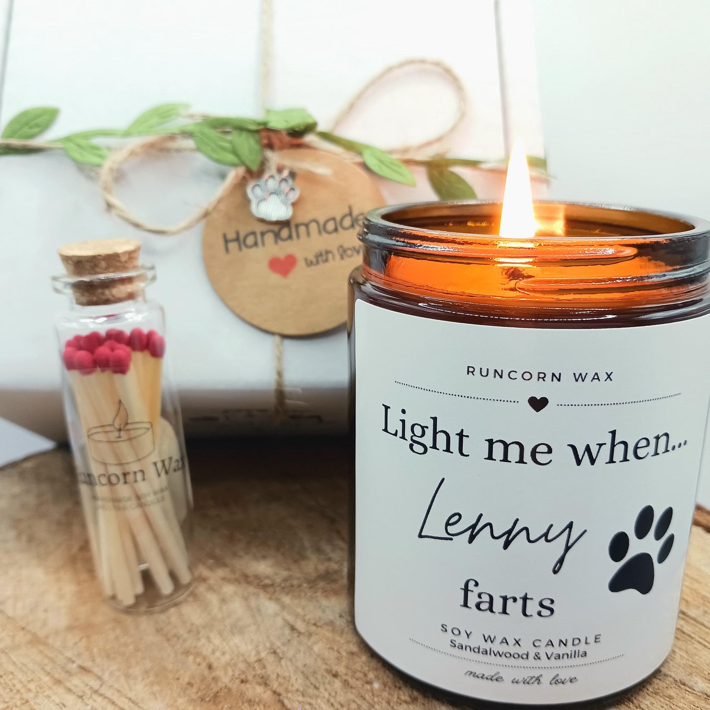 Candle labeled 'Light me when Lenny farts' with matches and a decorative tag in the background. dgg fart funny gift