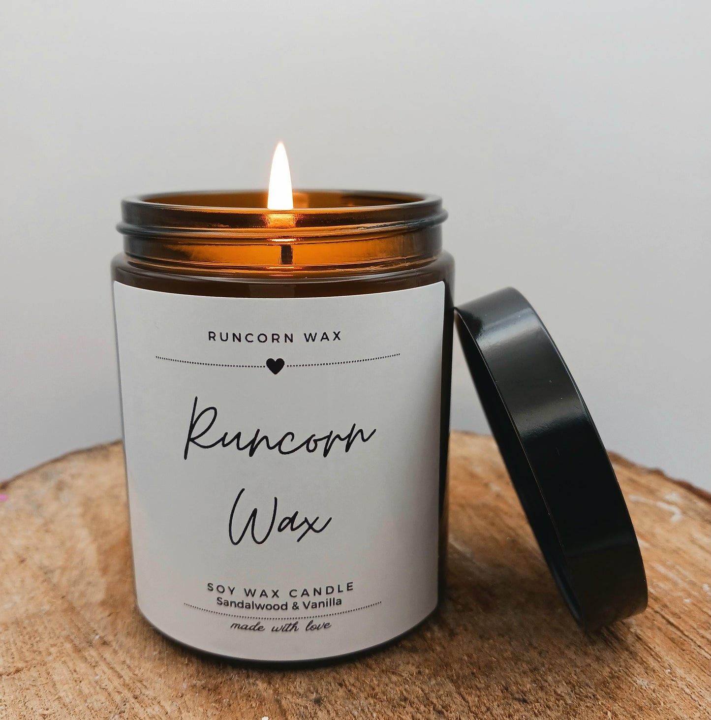 Candle with a label on a wooden surface