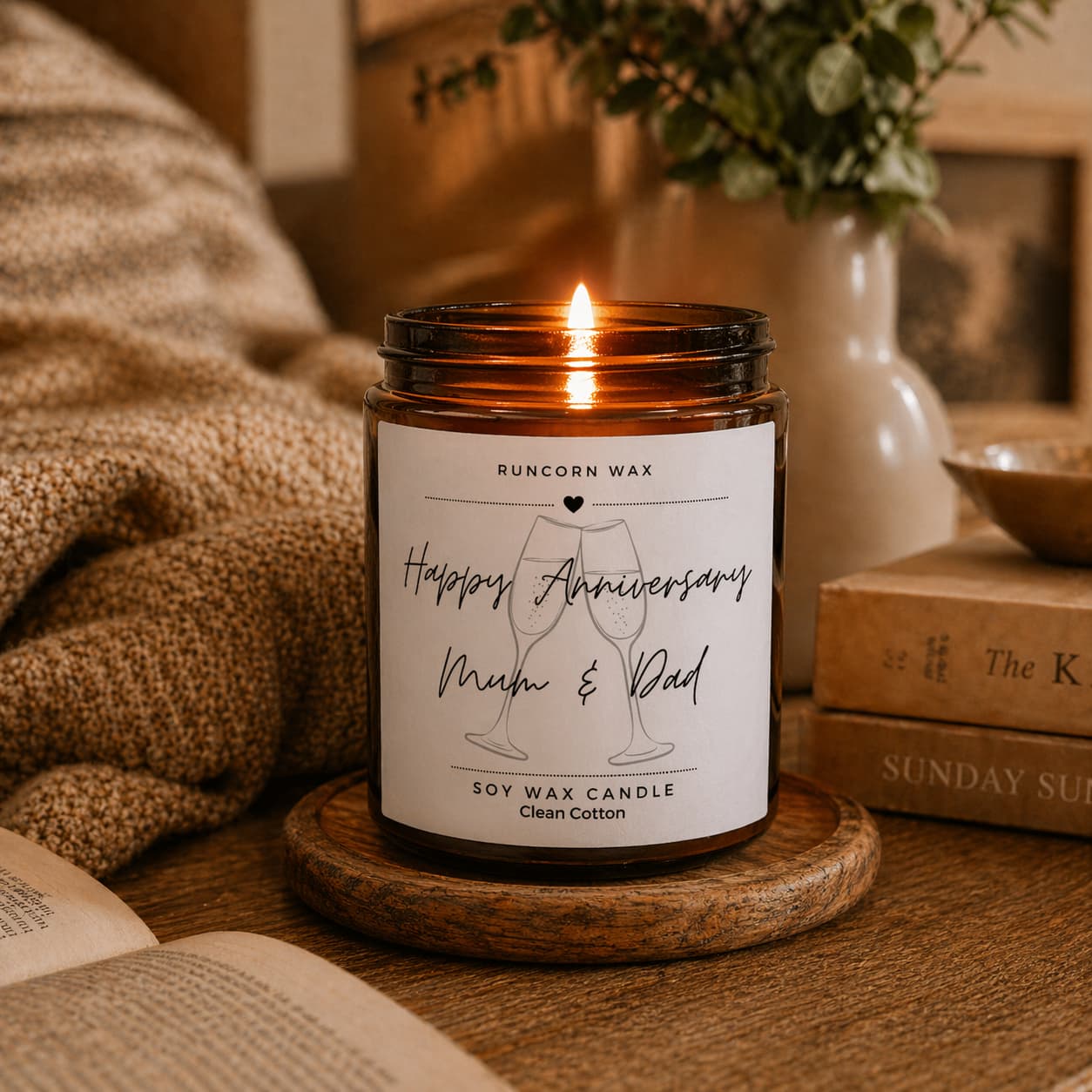 Candle with a 'Happy Anniversary Mum & Dad' label on a wooden surface.