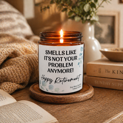 Funny retirement candle gift in amber jar, lit soy wax candle on wooden surface with cosy home decor, unique retirement gift idea