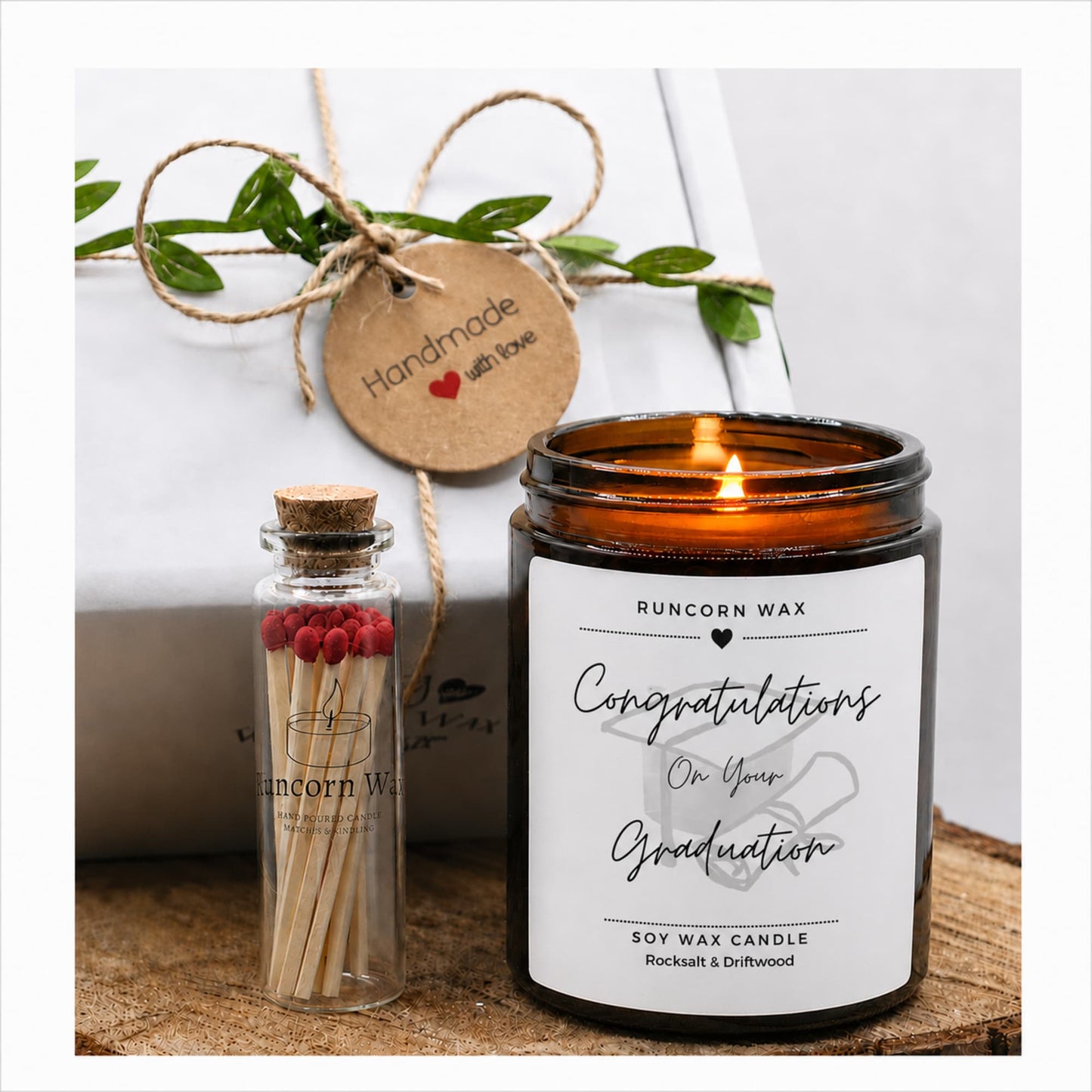 Graduation-themed candle with matches and decorative tag on a white background