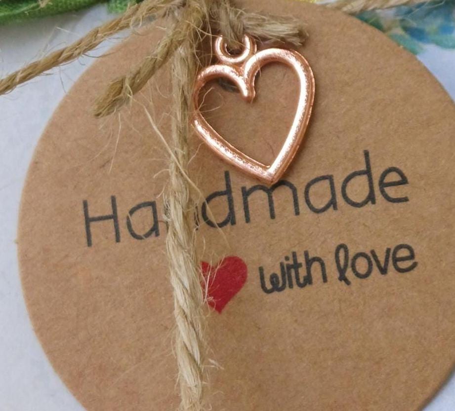 Round brown tag with heart-shaped charm and 'Handmade with love' text