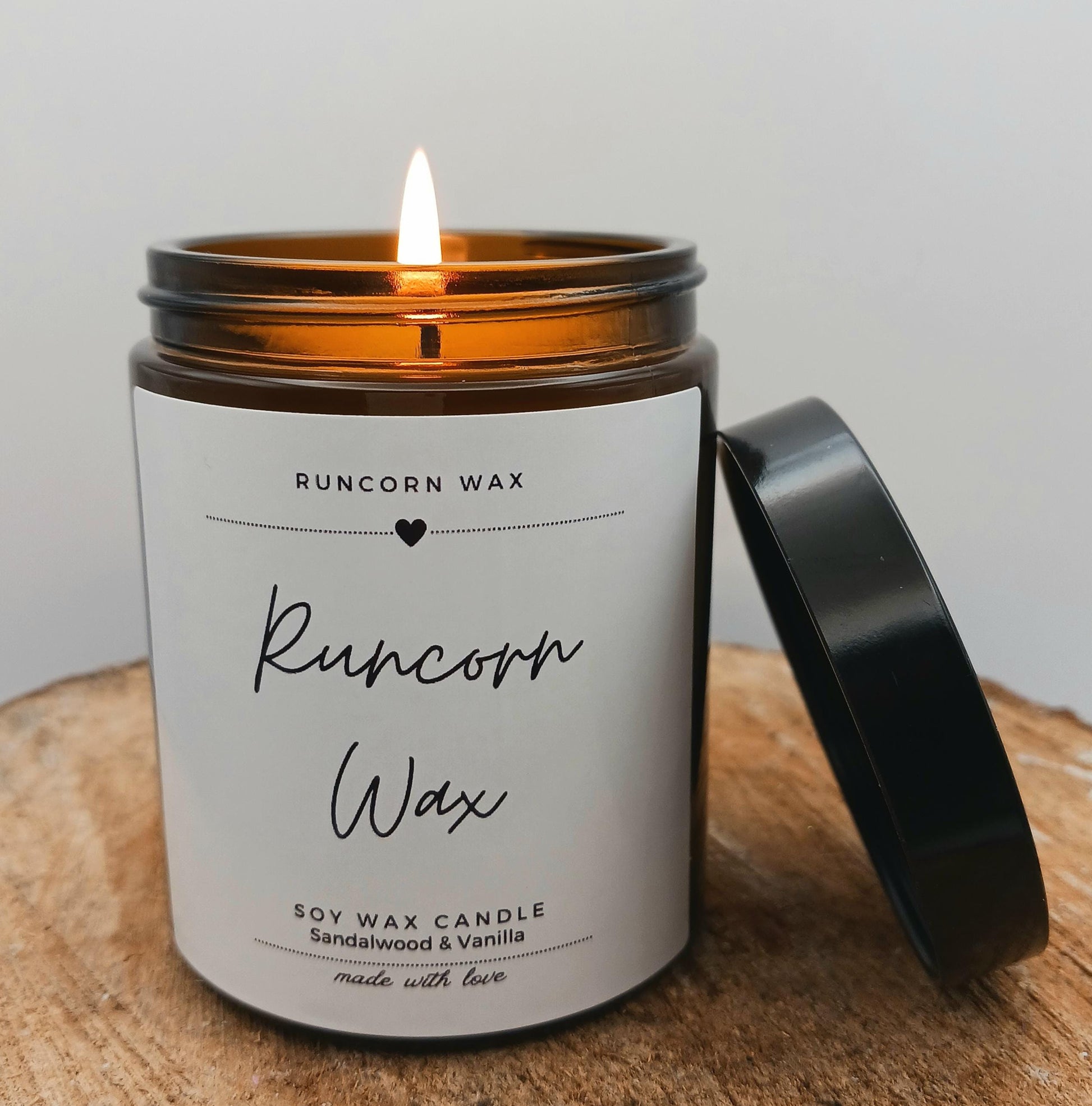 Candle with a label on a wooden surface