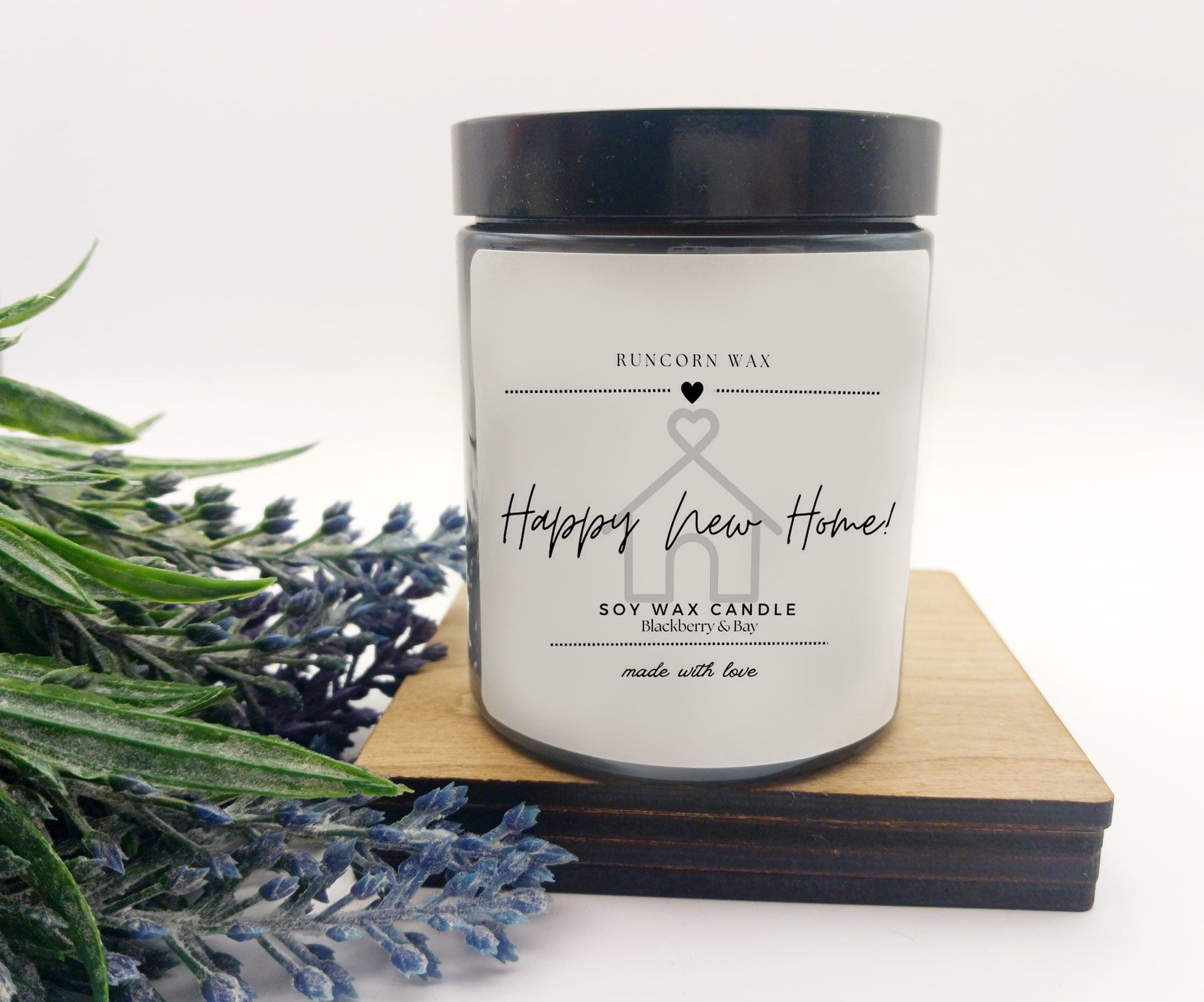 Candle with a 'Happy New Home' label on a white background