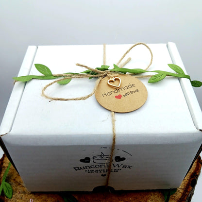 White gift box with a 'Handmade with Love' tag and greenery on a light gray background